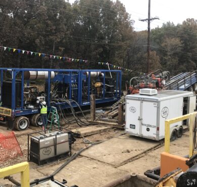 Horizontal directional drilling with machinery, pipes, cables, and trailers operating in Jefferson City, Missouri.