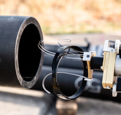 Sensor-equipped robot placed at large black pipe opening for horizontal directional drilling.