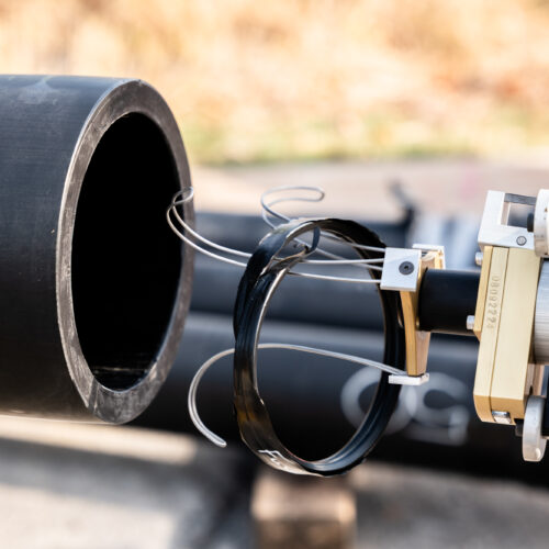 Sensor-equipped robot placed at large black pipe opening for horizontal directional drilling.