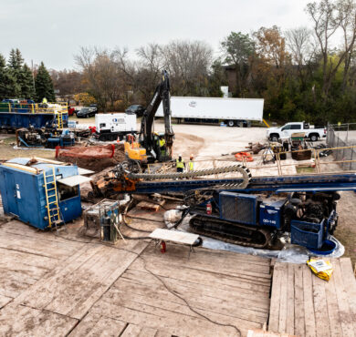 Horizontal directional drilling rig and equipment operate at a Wisconsin worksite under clouds.