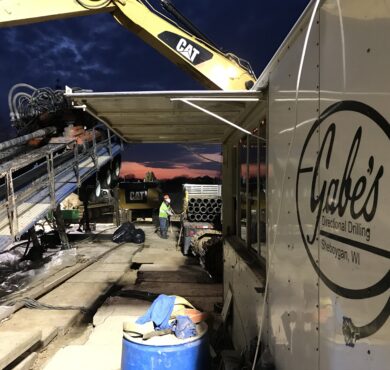 Workers run heavy machinery at Gabes horizontal directional drilling site, Sheboygan.