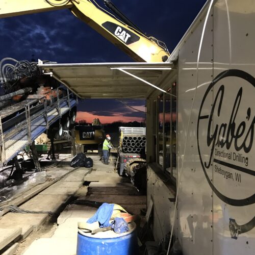 Workers run heavy machinery at Gabes horizontal directional drilling site, Sheboygan.