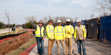 Five Gabe's construction workers in safety gear standing on a horizontal directional drilling jobsite next to trees in Green Bay, Wisconsin